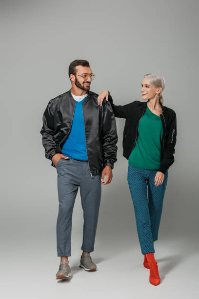 istock young smiling couple of models in stylish outfits on grey background 1018242534