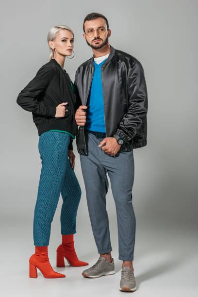 istock stylish couple of models posing in black jackets on grey background 1018242706
