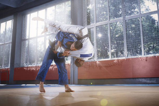 deux combattants de judo montrant des compétences techniques tout en pratiquant les arts martiaux dans un club de lutte - judo photos et images de collection