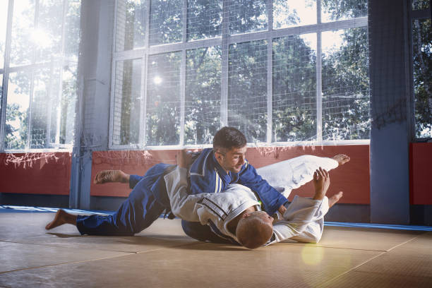 istock Two judo fighters showing technical skill while practicing martial arts in a fight club 1018245412