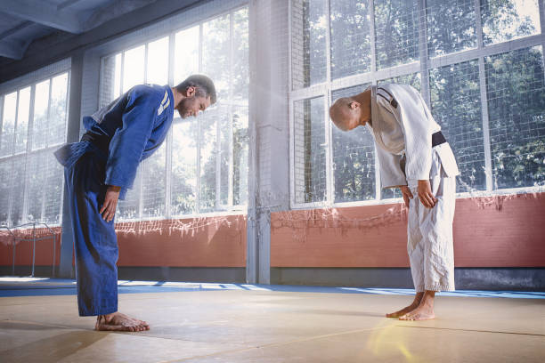 Two judo fighters greeting each other in a bow before practicing martial arts in a fight club