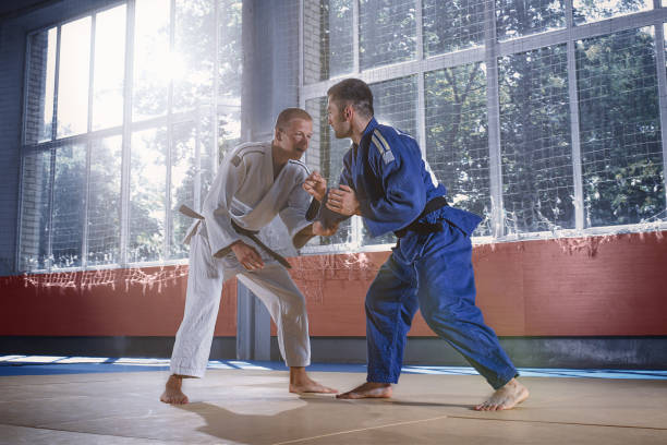 istock Two judo fighters showing technical skill while practicing martial arts in a fight club 1018245610