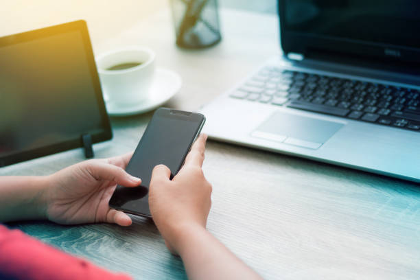 istock Hands of woman using smartphone on wooden table 1018246118