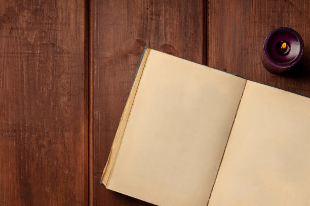 istock An old book with a candle on a dark rustic background with copy space 1018269760