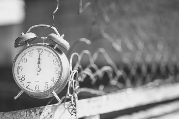 istock Alarm clock hanging on metal fence 1018272762