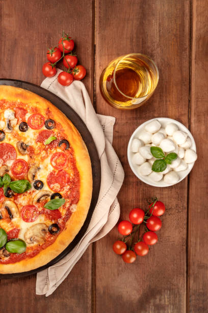 istock Pepperoni pizza with white wine, ingredients, and copy space 1018273084