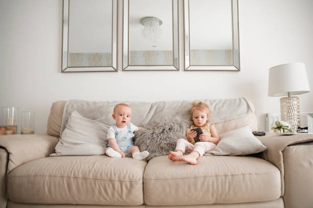 istock Brother And Sister Sitting On The Sofa 1018281876