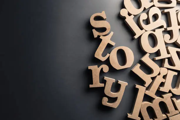 Scattered English letters with STORY word on black plastic background