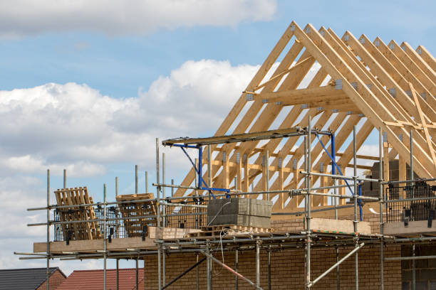 Construction industry. Timber framework of house roof trusses with scaffold. Construction industry. Timber framework of house roof trusses with scaffold on a building being built on a new housing estate. ian stock pictures, royalty-free photos & images