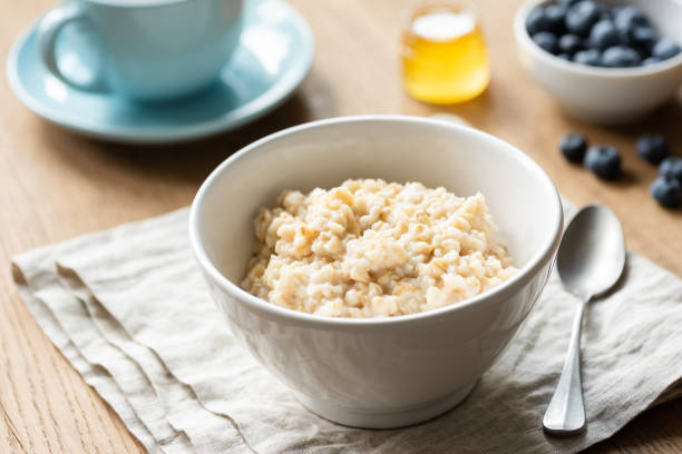 porridge di farina d'avena, avena scozzese in una ciotola - oatmeal heat bowl breakfast foto e immagini stock