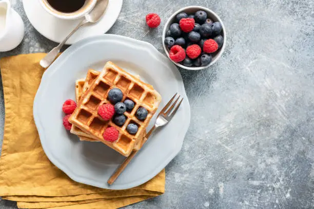 Photo of Belgian waffles, coffee and berries