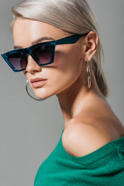 istock stylish female model in sunglasses looking at camera isolated on grey background 1018290942