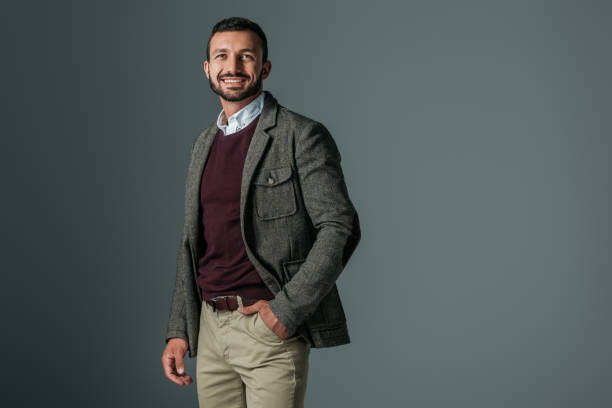 istock handsome smiling man posing in tweed jacket, isolated on grey 1018291268