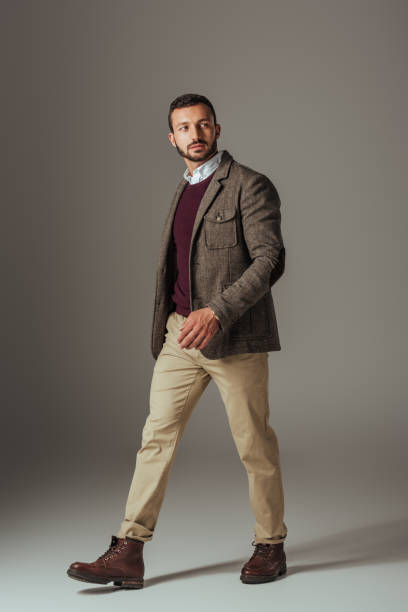 istock stylish man posing in beige pants and autumn tweed jacket, on grey 1018291336