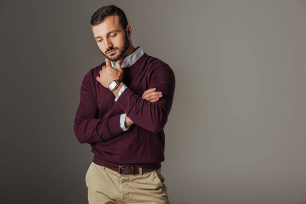 istock thoughtful handsome male model posing in burgundy sweater, isolated on grey 1018293402