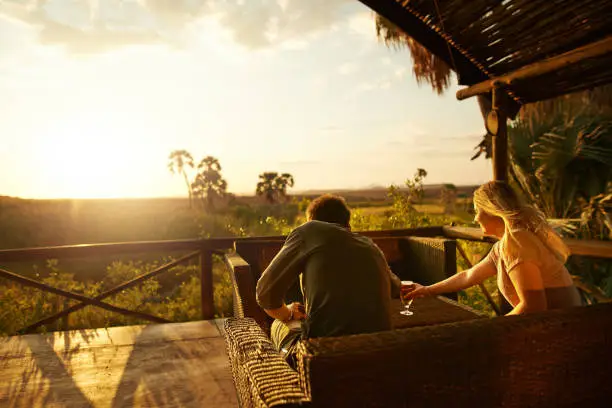 Rearview shot of an unrecognizable couple having a drink outside at a resort in nature