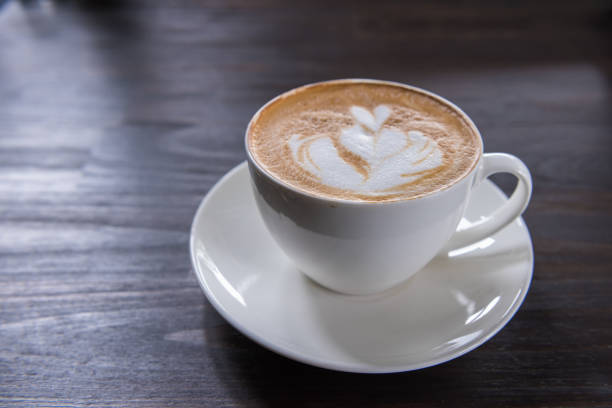 istock Latte art coffee cup with heart shape on wooden table, top view 1018305756