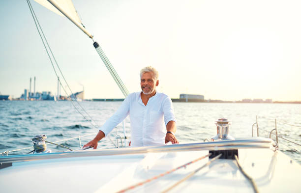istock Mature man standing on the deck of his sailboat 1018306020