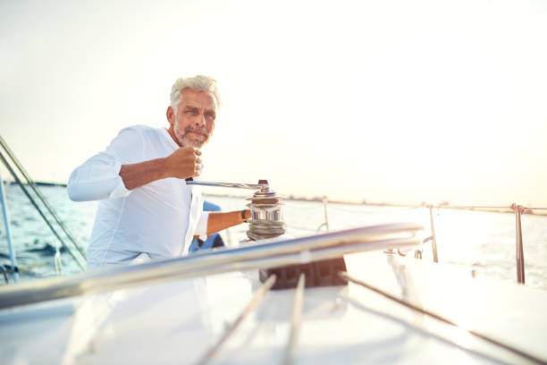 istock Mature man winding a winch on his sailboat 1018306054