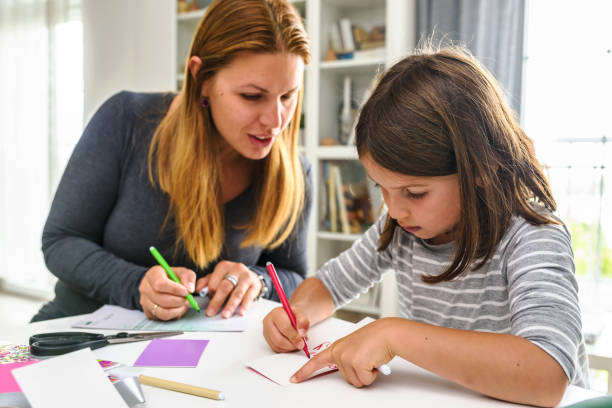 istock Mother teaching child at home how to write 1018306216