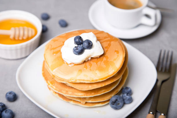 istock Pancakes with blueberries, sour cream, honey and coffee. 1018315146
