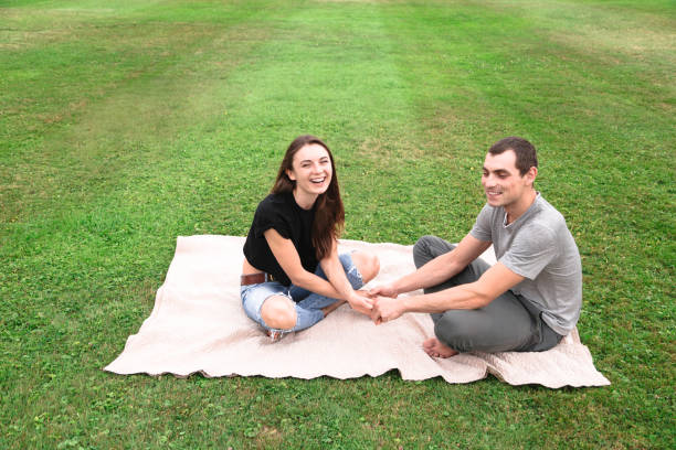 istock Young couple sit on a blanket on the grass 1018322766