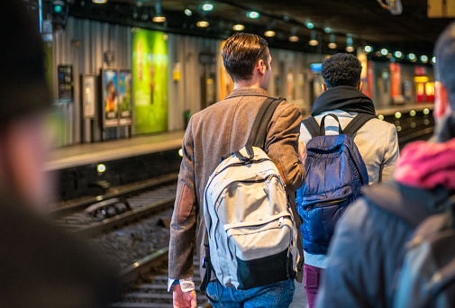 A rear view of passengers on the platform of a subway station in Paris, France.