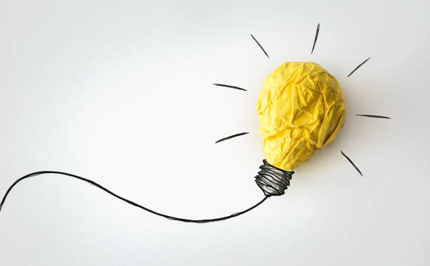 istock Ideas-Yellow crumpled paper ball and drawn bulb 1018327080
