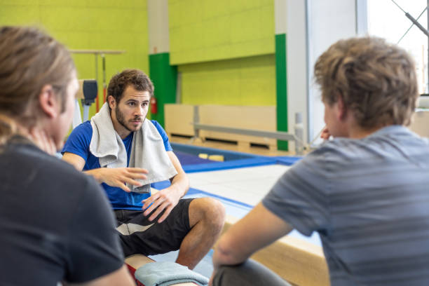 istock Gymnastics Athlete Having a Discussion with Two Adult Men 1018327142