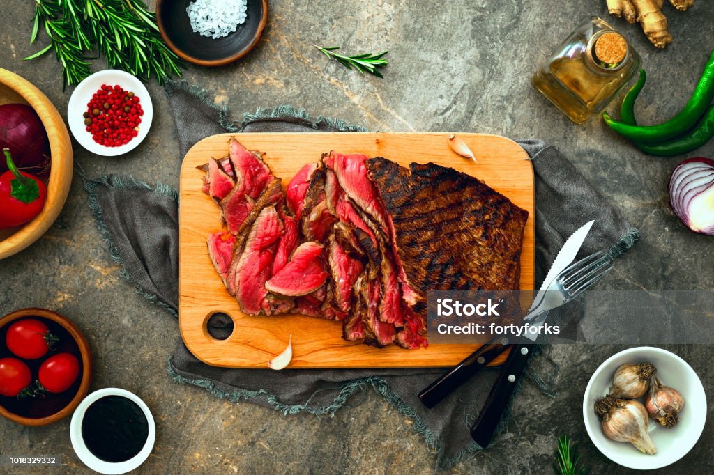 Grilled skirt steak served on a cutting board Grilled skirt steak fusion style marinated soya sauce and cooked, view from above, flat lay Barbecue - Meal Stock Photo