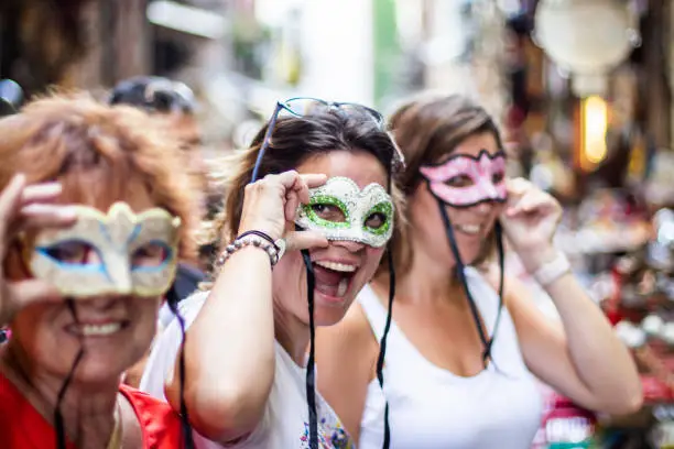 Three women with three masks on the streets of Naples, Italy