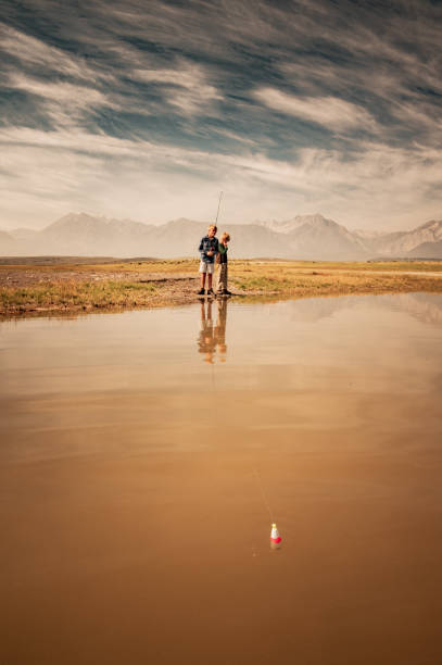 istock Two Young Boys Fishing On A Mountain Lake 1018337904