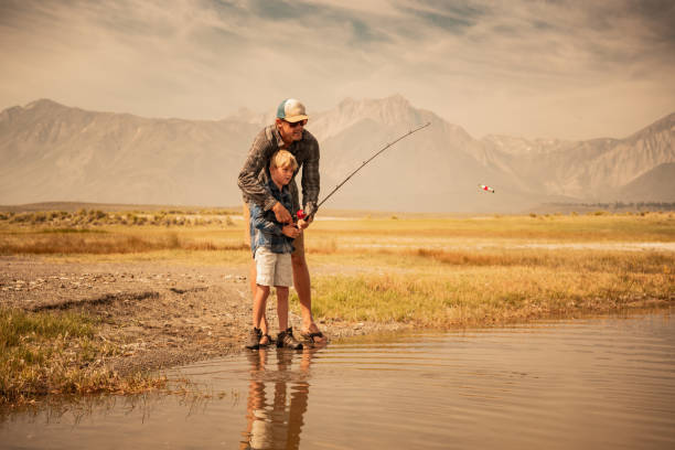 ojciec i syn połowów na jeziorze górskim - fishing rod fishing fishing reel casting zdjęcia i obrazy z banku zdjęć