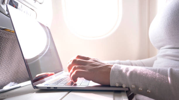 istock CLOSE UP: Unrecognizable woman types on her modern laptop while flying overseas. 1018346768