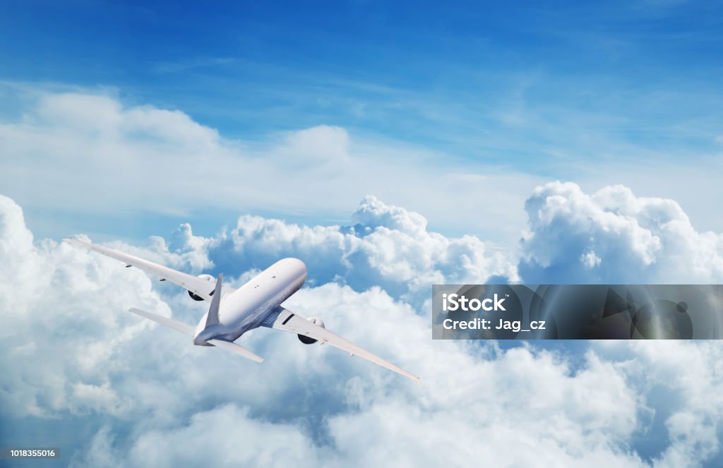 Commercial airplane flying above clouds Back view of commercial airplane flying above clouds. Copyspace for text Airplane Stock Photo