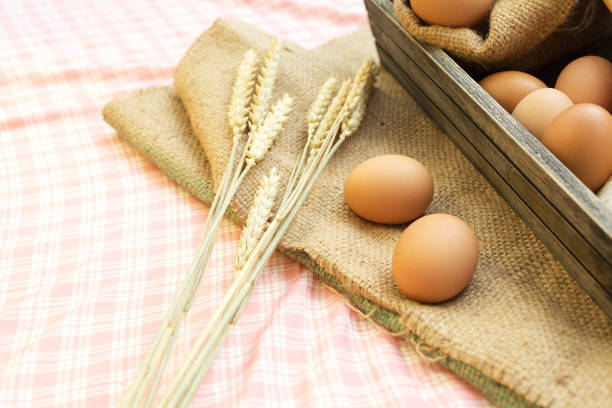 istock Breakfast and baked bread concept. Fresh fragrant bread and egg on the fabric sack. On table. 1018357778