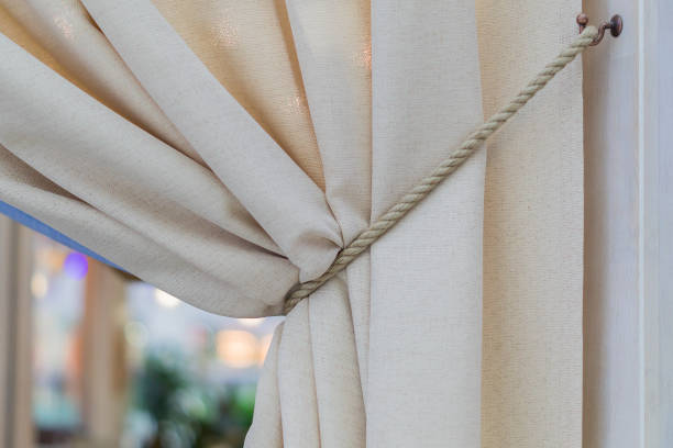interior design element - beige curtains tied with cord, italian style