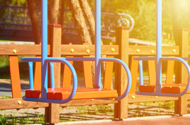 swing for children in the public playground, sunlight effect - mirth imagens e fotografias de stock