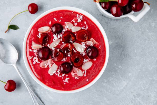 istock Red cherry smoothie with fresh berries, almond flakes and coconut chips. 1018364892