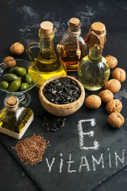 Photo of Food containing vitamin E. Oil and seeds rich in vitamin E. Selective focus.