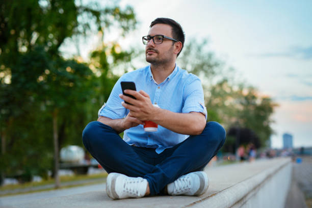 istock Young handsome male using mobile phone and looking away 1018383606