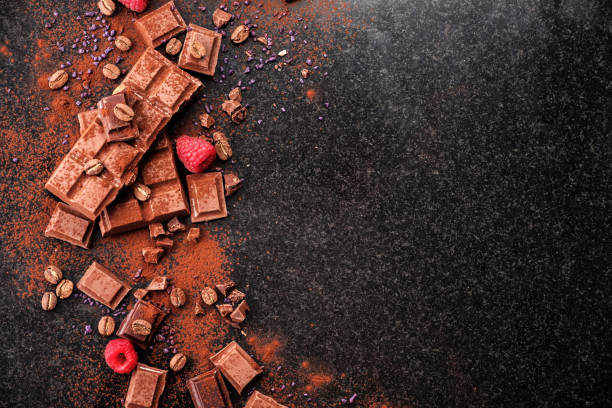 istock Broken chocolate pieces and cocoa powder on marble. 1018383780