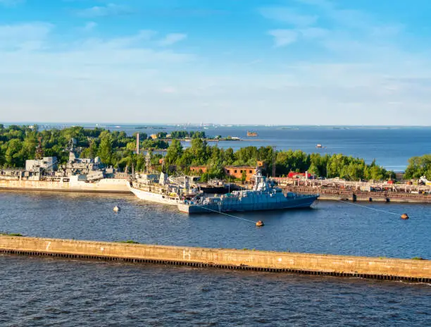 Military vessels moored in one of the harbours of Kotlin Island, Russia. Kotlin Island is an island in the Gulf of Finland, connected to mainland Russia by the St Petersburg Ring Road along the St Petersburg Dam, punctuated by tunnels to allow shipping through. The main town is Kronstadt, a heavily fortified town built to protect the city of St Petersburg. It is still home to part of the Russian navy but many of the defences are in a state of decay. In the distance one of the St Petersburg Ring Road bridges can be seen.