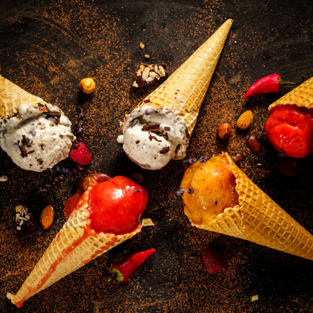 istock Different varieties of ice cream in waffle cones on the table, top view 1018386994