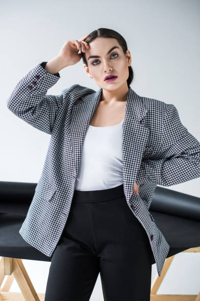 istock beautiful young woman posing in elegant retro suit, on grey 1018410108