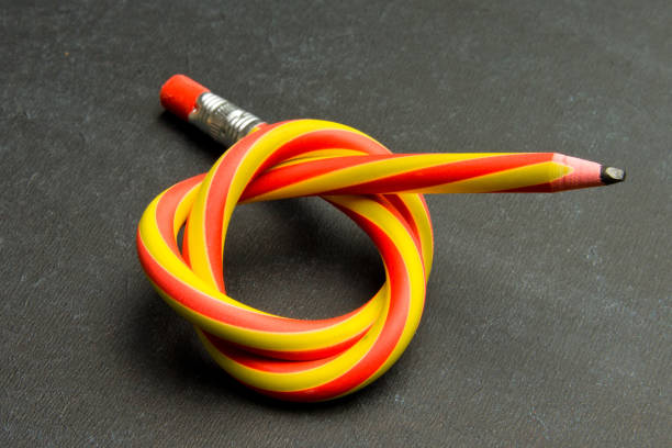 istock Flexible pencil on a textured cardboard background. Bent pencils two-color 1018416928