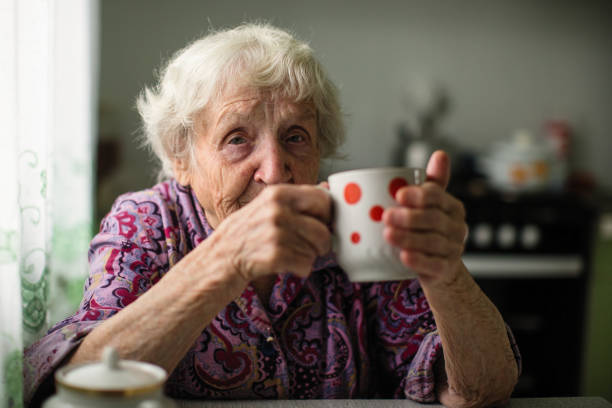 istock An elderly woman drinking tea sitting in the kitchen. 1018445586