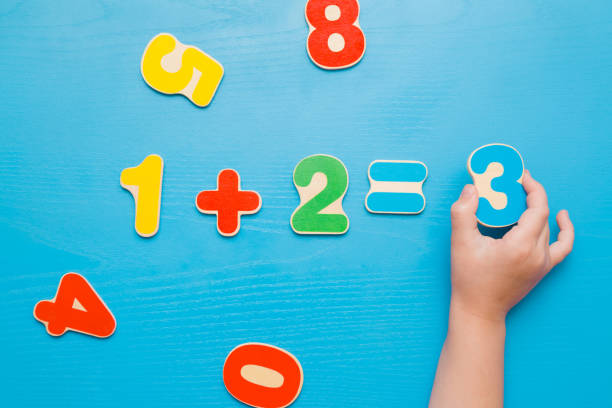 coloridos números de aprendizaje para los niños pequeños sobre la mesa azul. mano de la chica poniendo número tres. respuesta correcta. tiempo para aprender. concepto de educación. vista superior. - mathematics mathematical symbol preschool simplicity fotografías e imágenes de stock