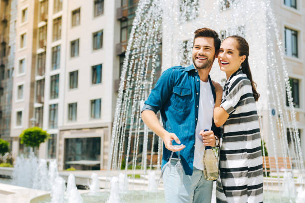 istock Delighted nice couple standing near the fountain 1018456036