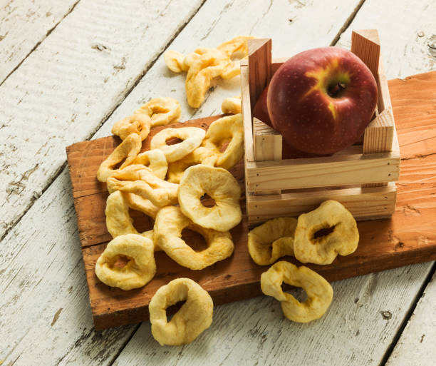 pomme en tranches et séchée avec des pommes fraîches sur la table en bois - dried apple photos et images de collection